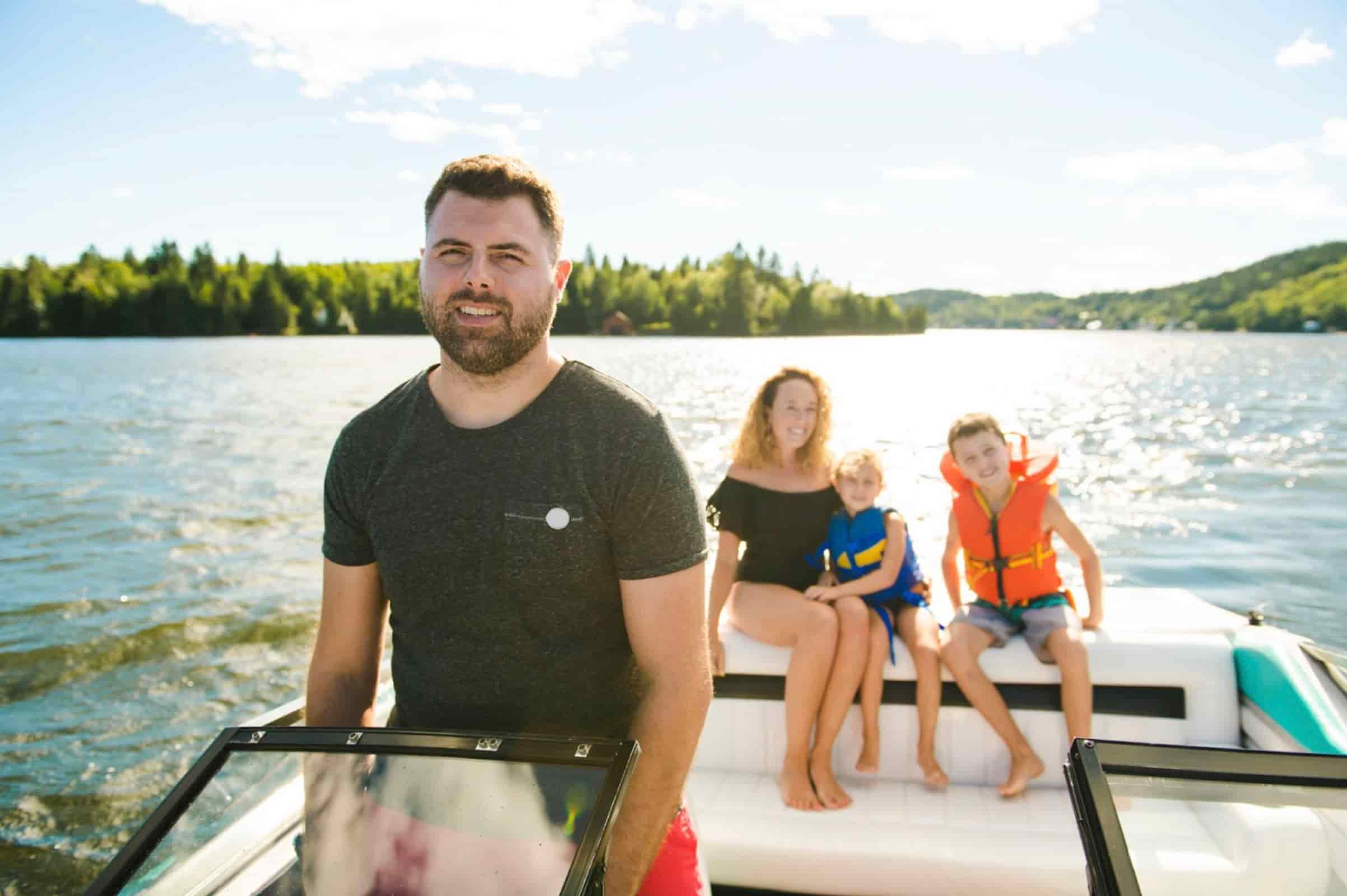 Father driving a boat with his family